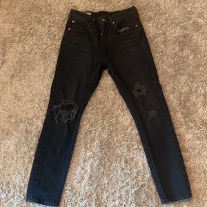 Levi’s 501 S Skinny black jeans, with rips on both knees.